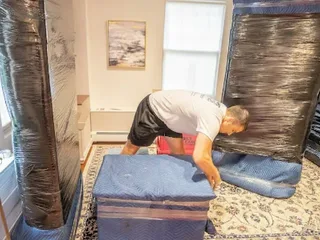 Movers carefully wrapping furniture